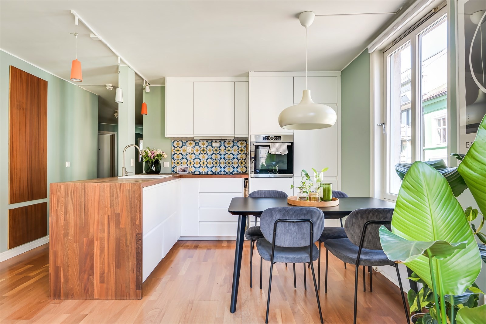 Stilren innredning med hvite fronter, fliser over benkeplaten og pen benkeplate. Galleribilde