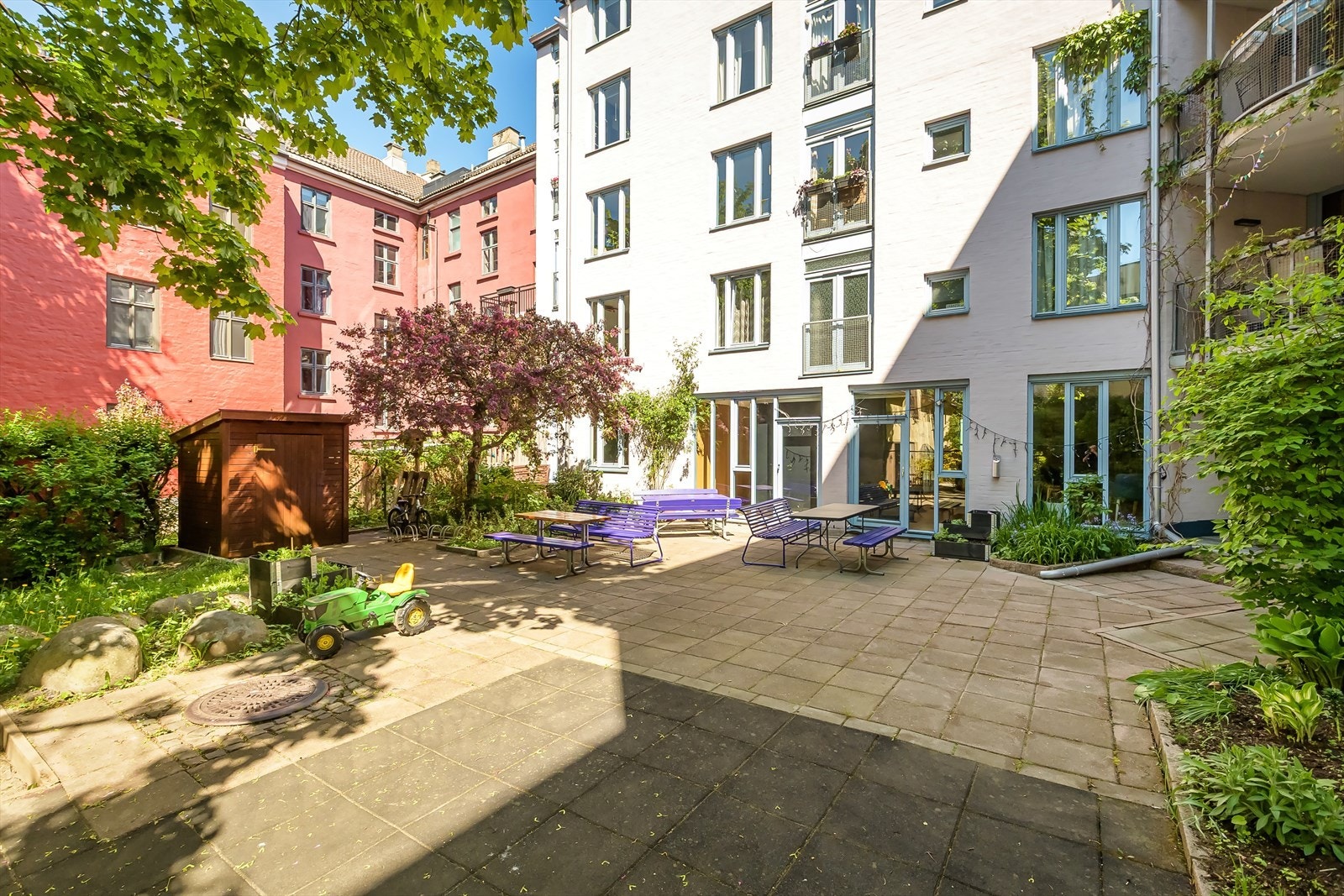 Lekeplass og benker, et koselig uteområde hvor både barn og voksne kan trives. Galleribilde