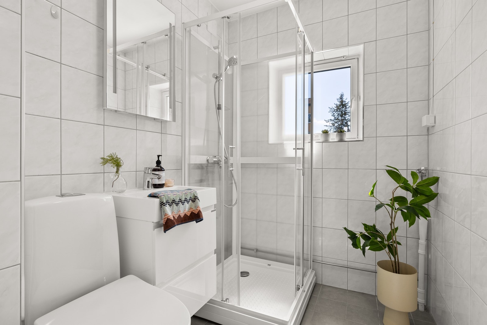 Fra entréen er direkte adkomst til flislagt baderom som ble pusset opp i 2018. Galleribilde