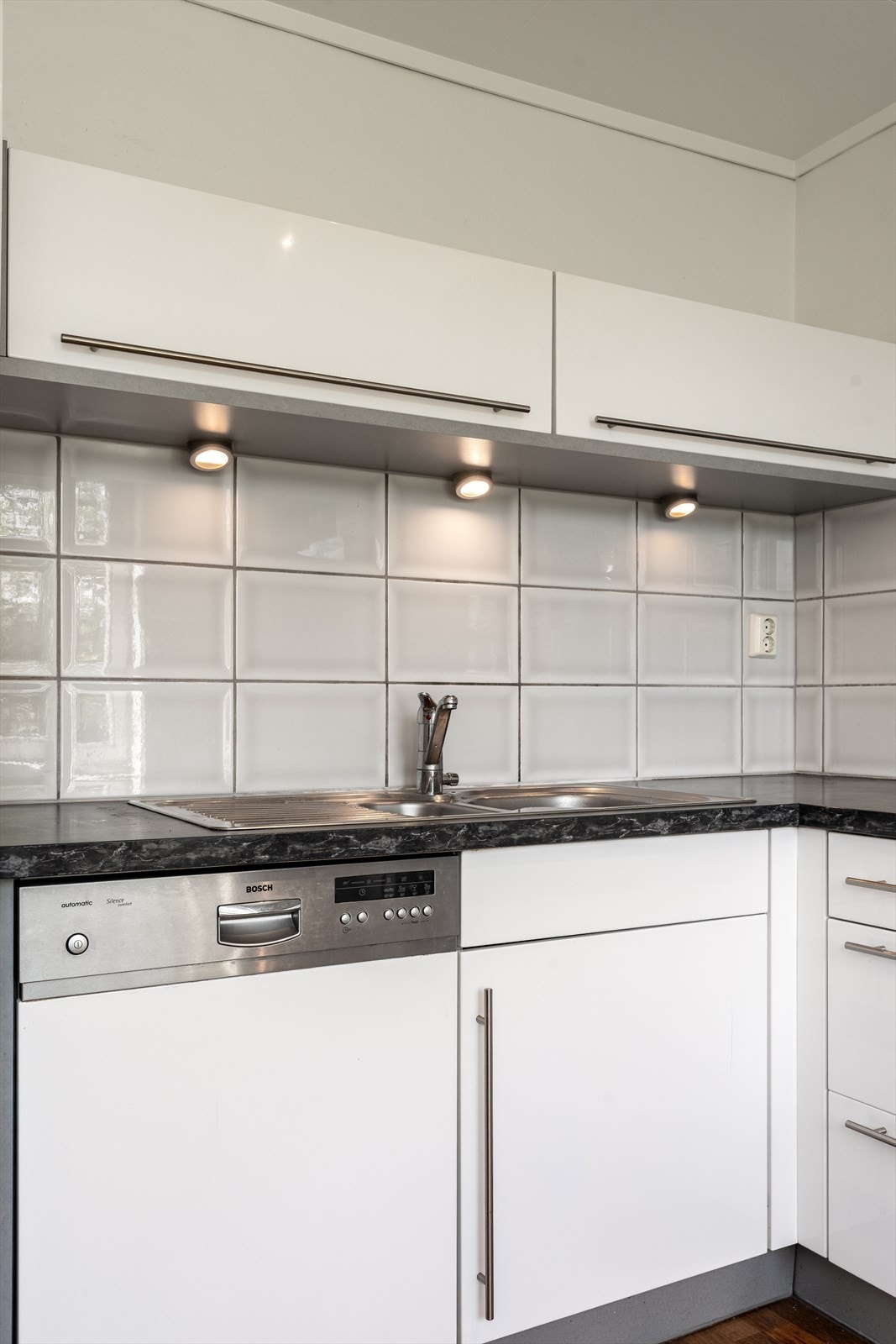 Stilige overskap med spotter og gjennomgående detaljer i stål tilfører rommet et moderne preg. Galleribilde