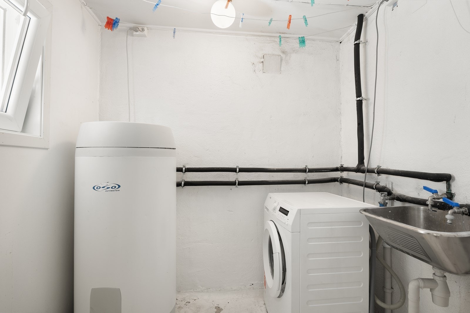 Grovt vaskerom med utslagsvask og opplegg for vaskemaskin Galleribilde