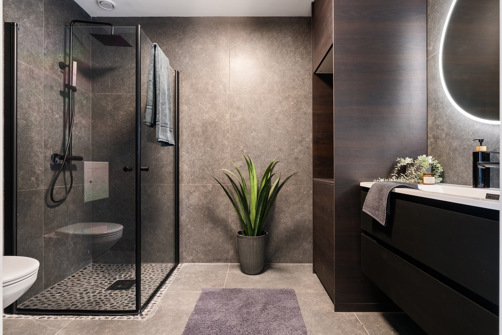 Lekkert bad med flis på gulv og vegger. Varmekabler i gulv. Innredning med plass til kompakt vaskemaskin. Galleribilde