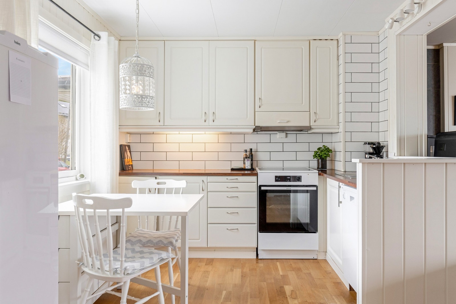 Lyst kjøkken med hyggelig spiseplass ved vinduet Galleribilde