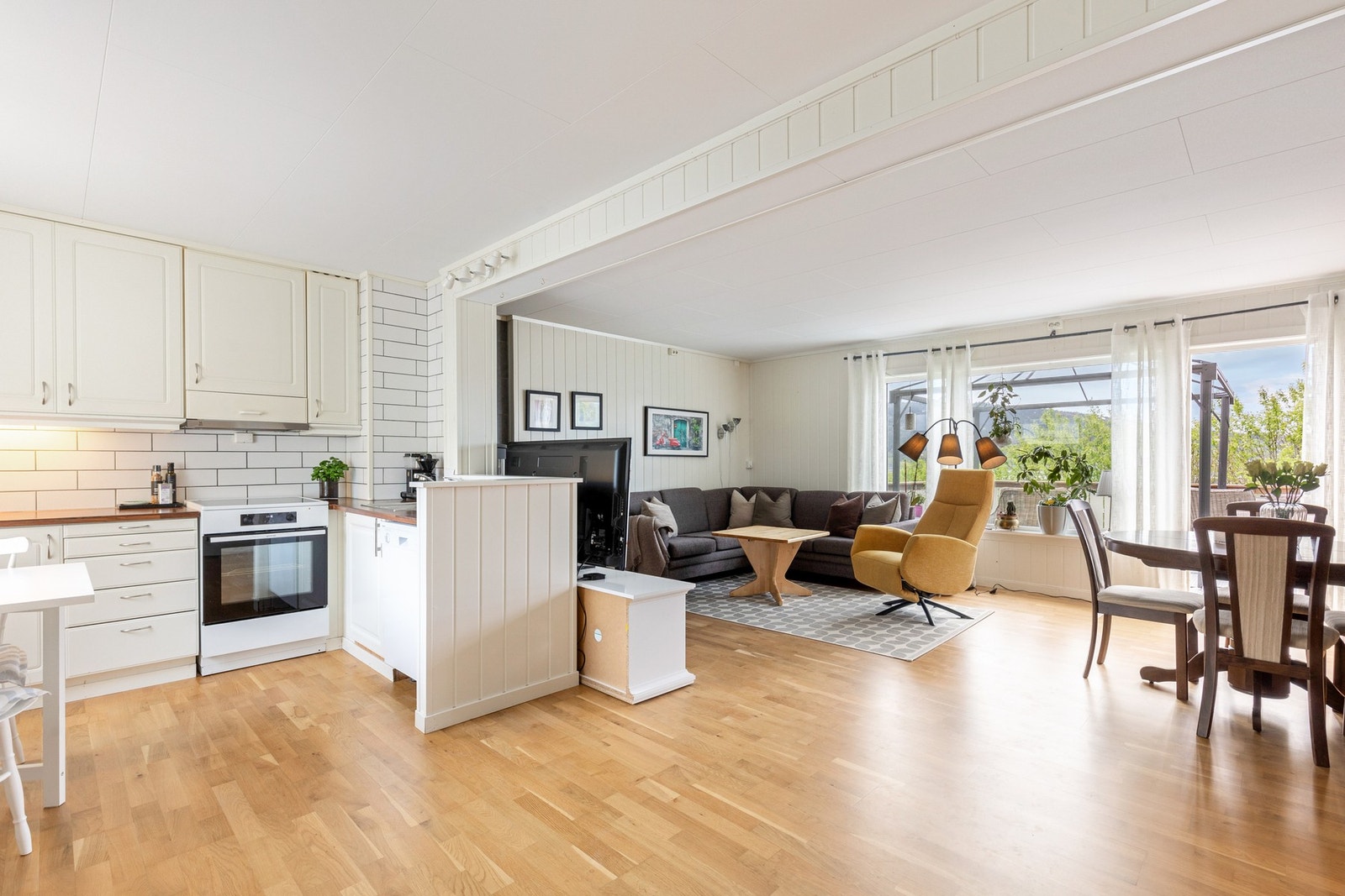 Boligen har en lys og åpen løsning mellom stue og kjøkken som bidrar til flere sosiale soner Galleribilde