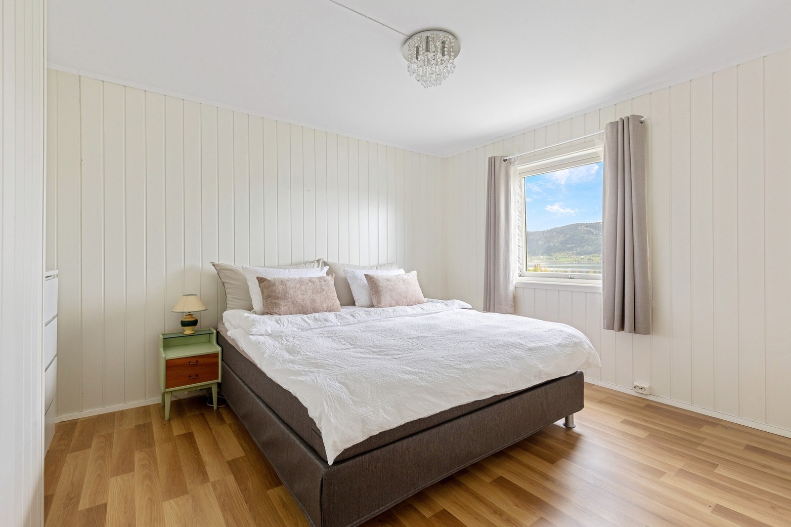 Hovedsoverommet | Lyst og luftig soverom som rommer plass til dobbeltseng, nattbord og garderobeløsning Galleribilde