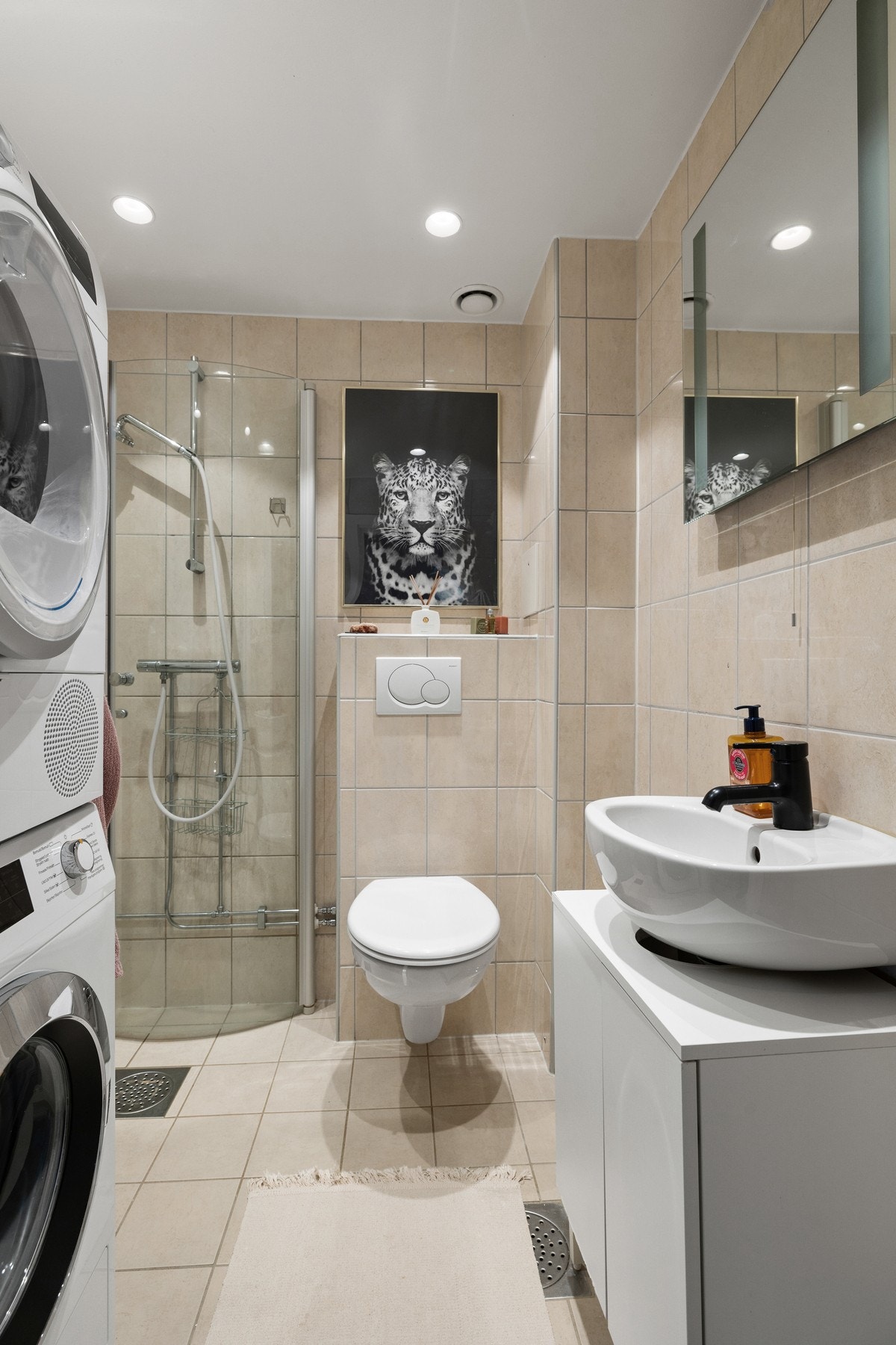 Badet er smakfullt innredet med bl.a. veggmontert toalett, samt dusjhjørne med innfellbare glassvegger. Galleribilde