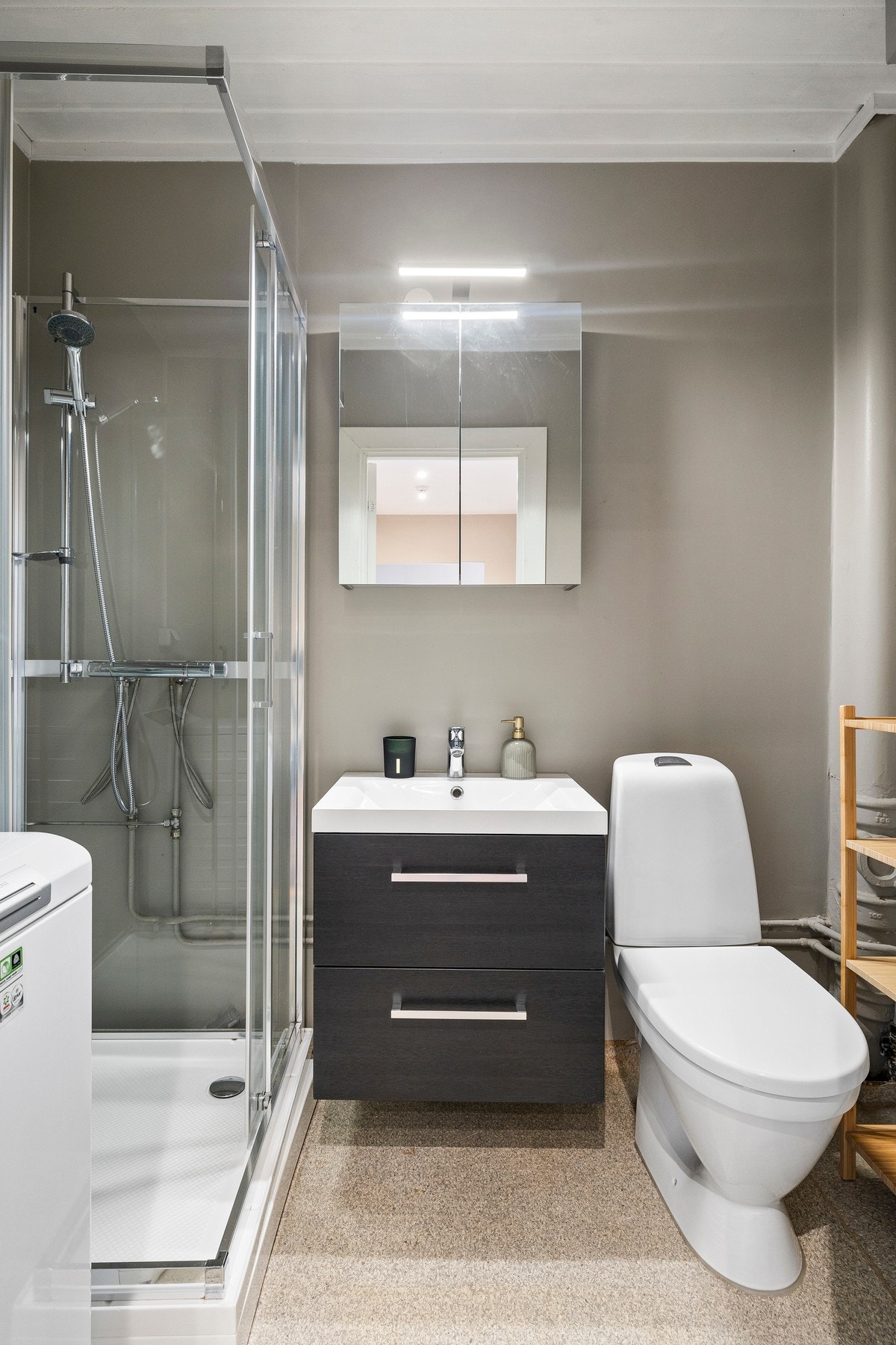 Badet har innredning med sorte slette fronter og heldekkende servant med 1-greps blandebatteri. Galleribilde