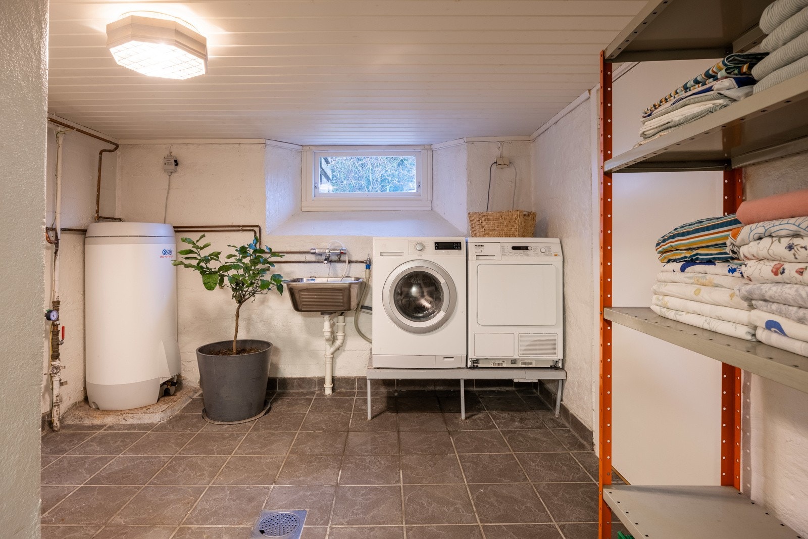 Vaskerom i kjeller med opplegg og plass for vaskemaskin og tørketrommel. Galleribilde