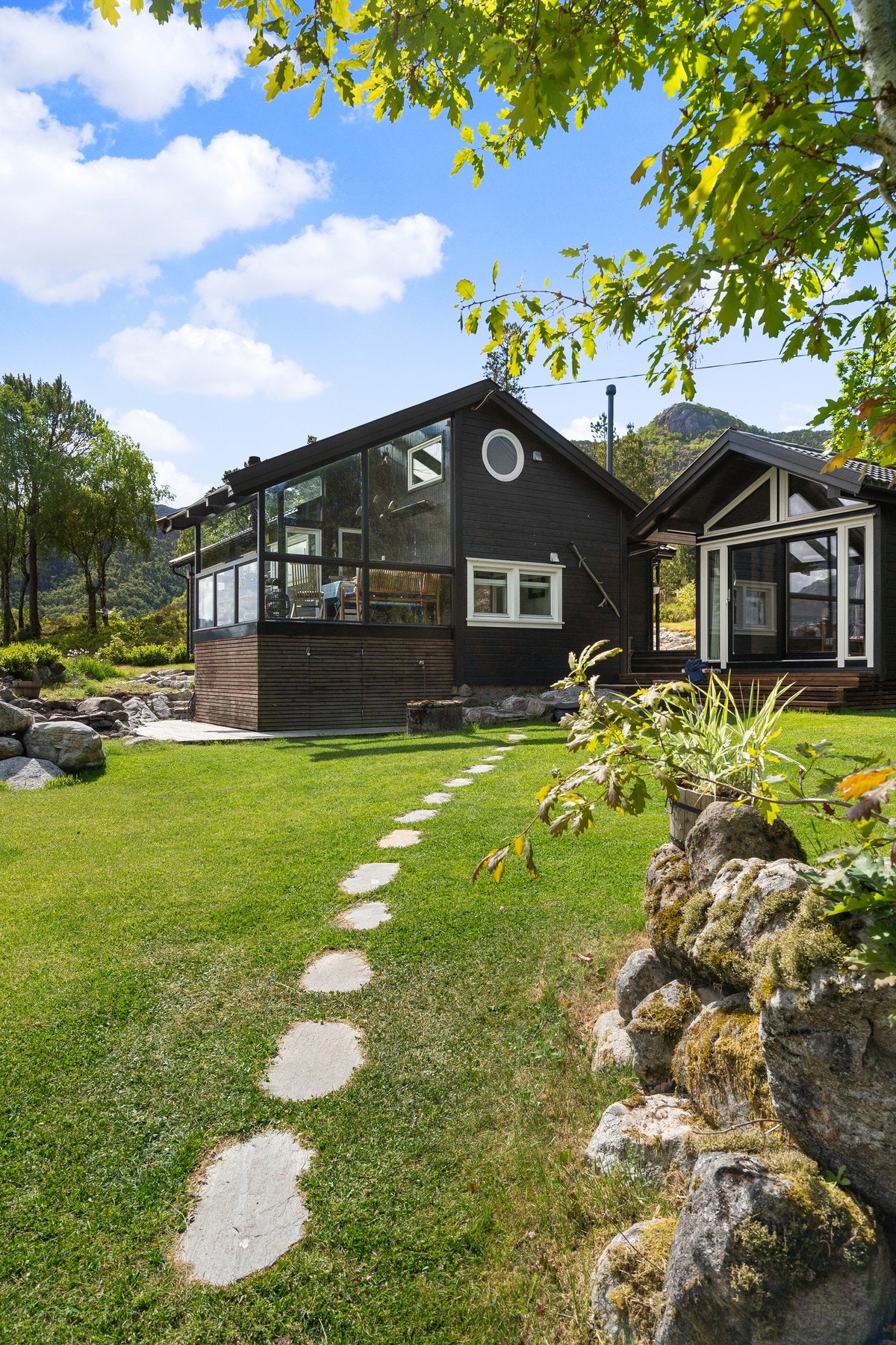 Fasaden på denne siden av hytta er fra 2022 med terrasse med glasstak. Anneks/bod er også oppført da. Galleribilde