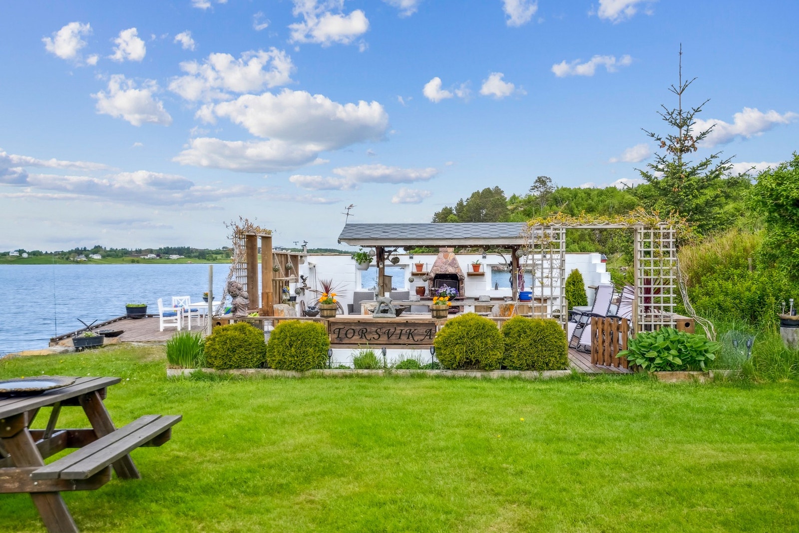 Nede ved kaien finnes et utekjøkken som er oppbygd på et terrassedekke, og med vegger av malt murstein. Det er målt til å ha et gulvareal på cirka 41 kvm Galleribilde