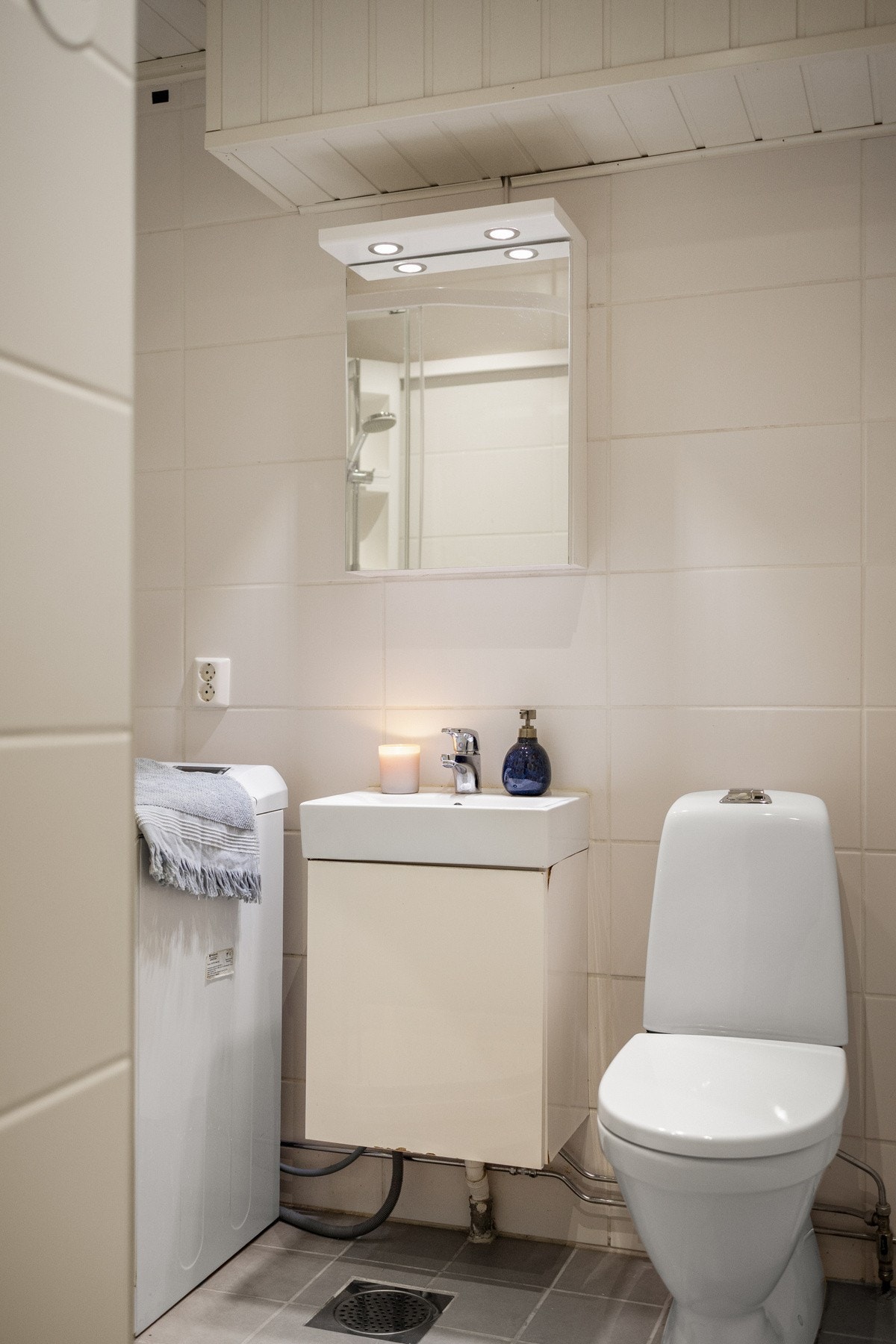 Flott baderom bestående av servant med underskap, dusjkabinett og gulvstående toalett Galleribilde