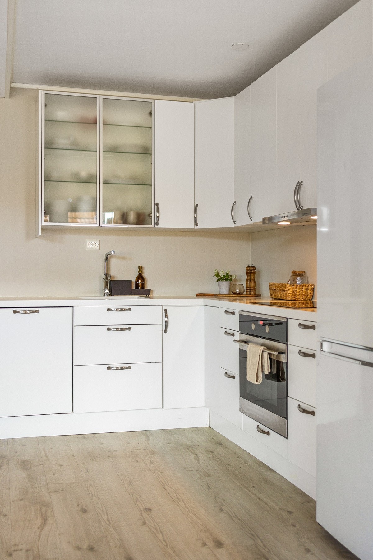 Kjøkkenet har integrerte hvitevarer som platetopp, stekeovn, oppvaskmaskin og frittstående kjøleskap Galleribilde