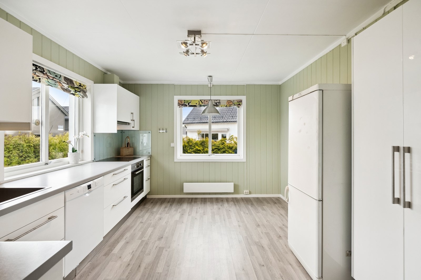 Ved inngangen til kjøkkenet er det plassert et dobbelt høyskap som er innredet med skuffer og hyller. Det er plass til frittstående kombiskap med kjøl/frys ved siden av høyskapet. Galleribilde