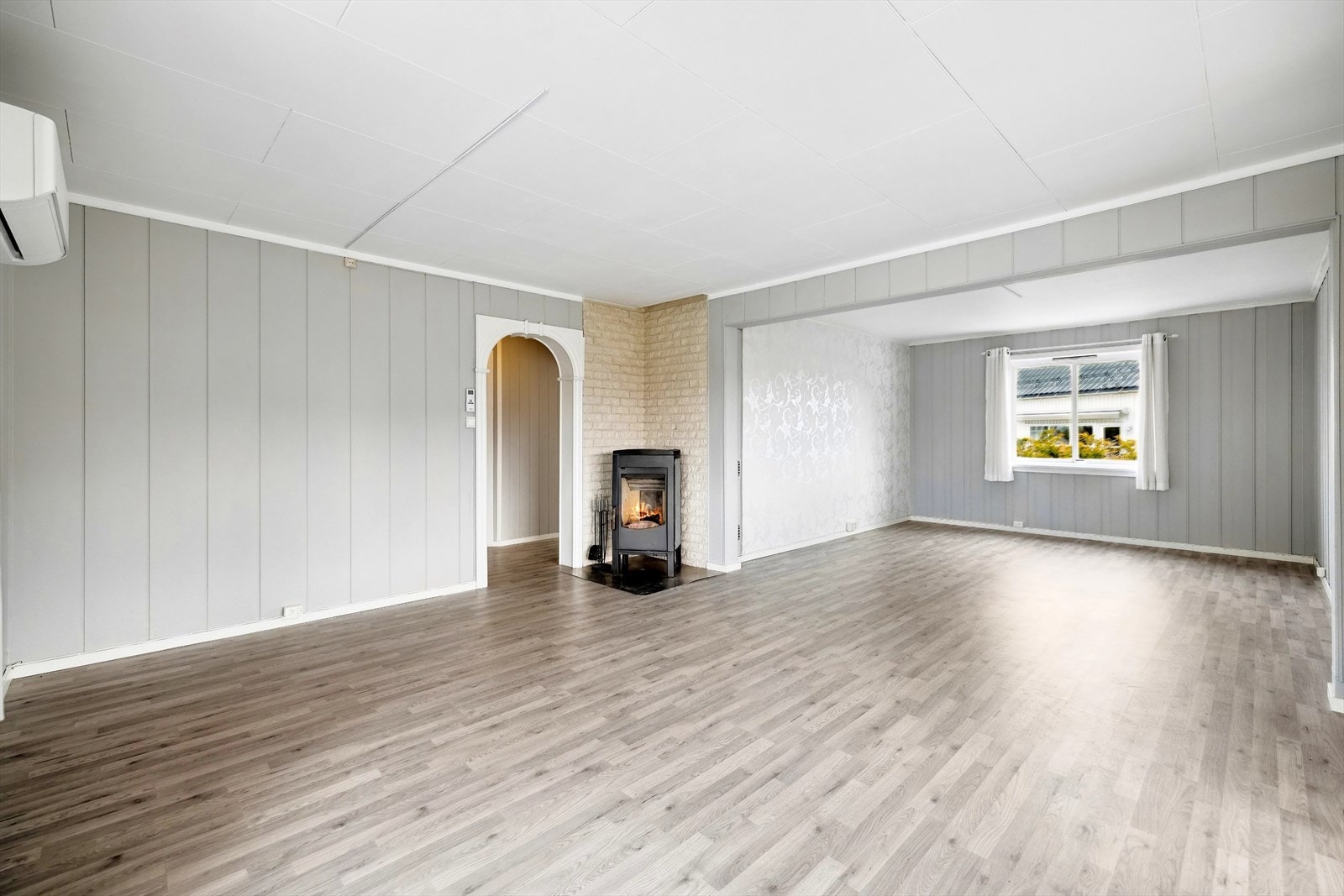 Stuen er romslig med flere soner og har en lukket peisovn med kleberstein og glassdør. Galleribilde