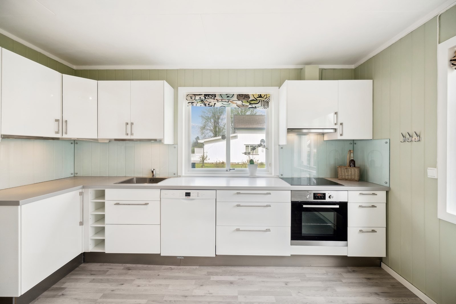 Kjøkkenet har integrerte hvitevarer med induksjons platetopp, ventilator over kokeplass med avkast via yttervegg, stekeovn og oppvaskmaskin. Galleribilde