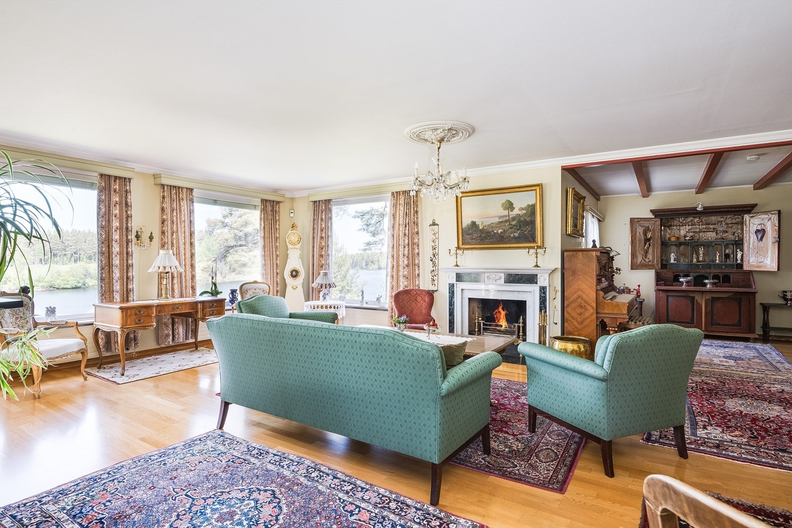 Stuen har fine detaljer som en lekker åpen peis og en klassisk rosett i himlingen. Galleribilde