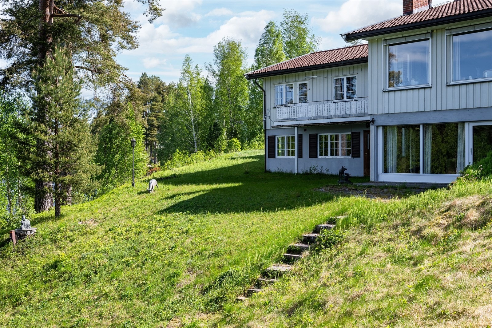 Hellende tomt mot vest og trapp av naturstein i skråning. Galleribilde