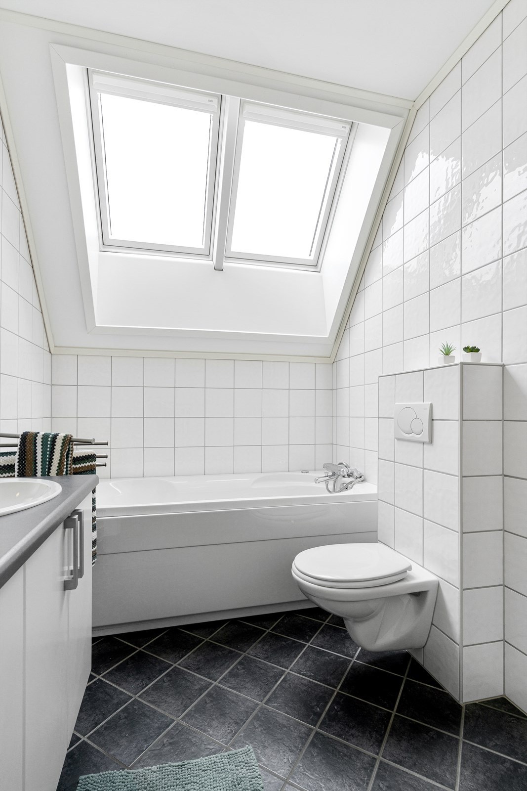 Badet har vegghengt toalett og badekar. Galleribilde