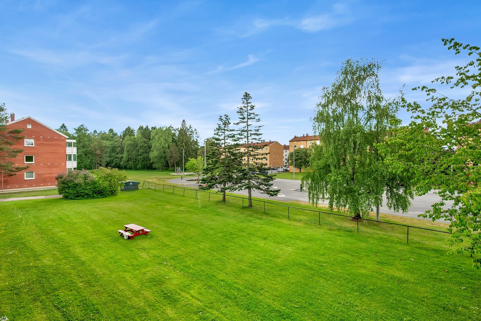 Fra balkongen er det grønt, åpent og fint utsyn mot borettslagets fellesareal. Galleribilde