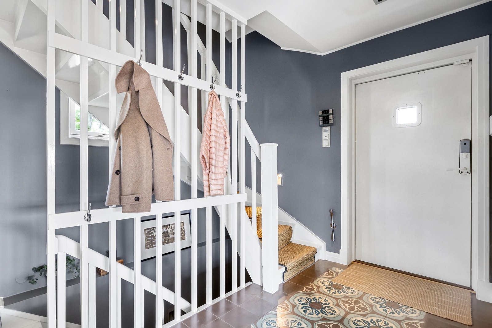 Innbydende entré med flislagt gulv og elektrisk gulvvarme, og veggene er malt i moderne fargevalg. Galleribilde