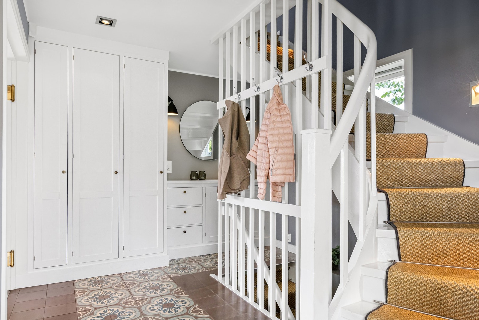 Det er plassbygde garderobeskap som sikrer god oppbevaringsplass. En elegant vinkeltrapp med rekkverk i tre leder videre opp og ned i etasjene. Galleribilde