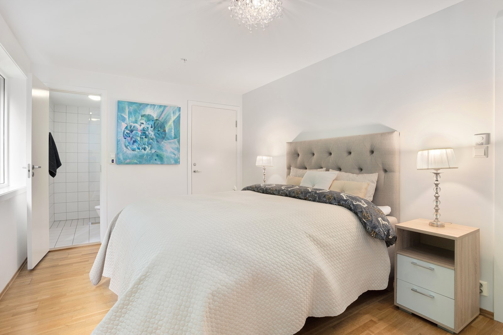 Lyst og romslig soverom med inngang til eget bad og bod med skyvedørsgarderobe og hylleinnredning. Galleribilde