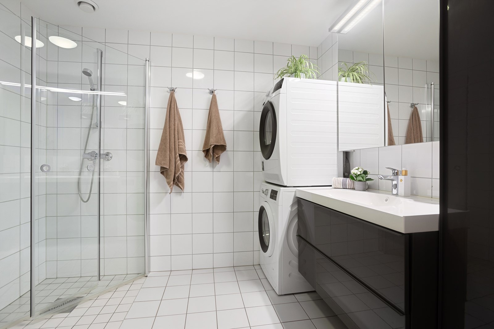 Stort bad med dusjhjørne, servant med skuffer, speil og wc. Opplegg for vaskemaskin og tørketrommel. Galleribilde