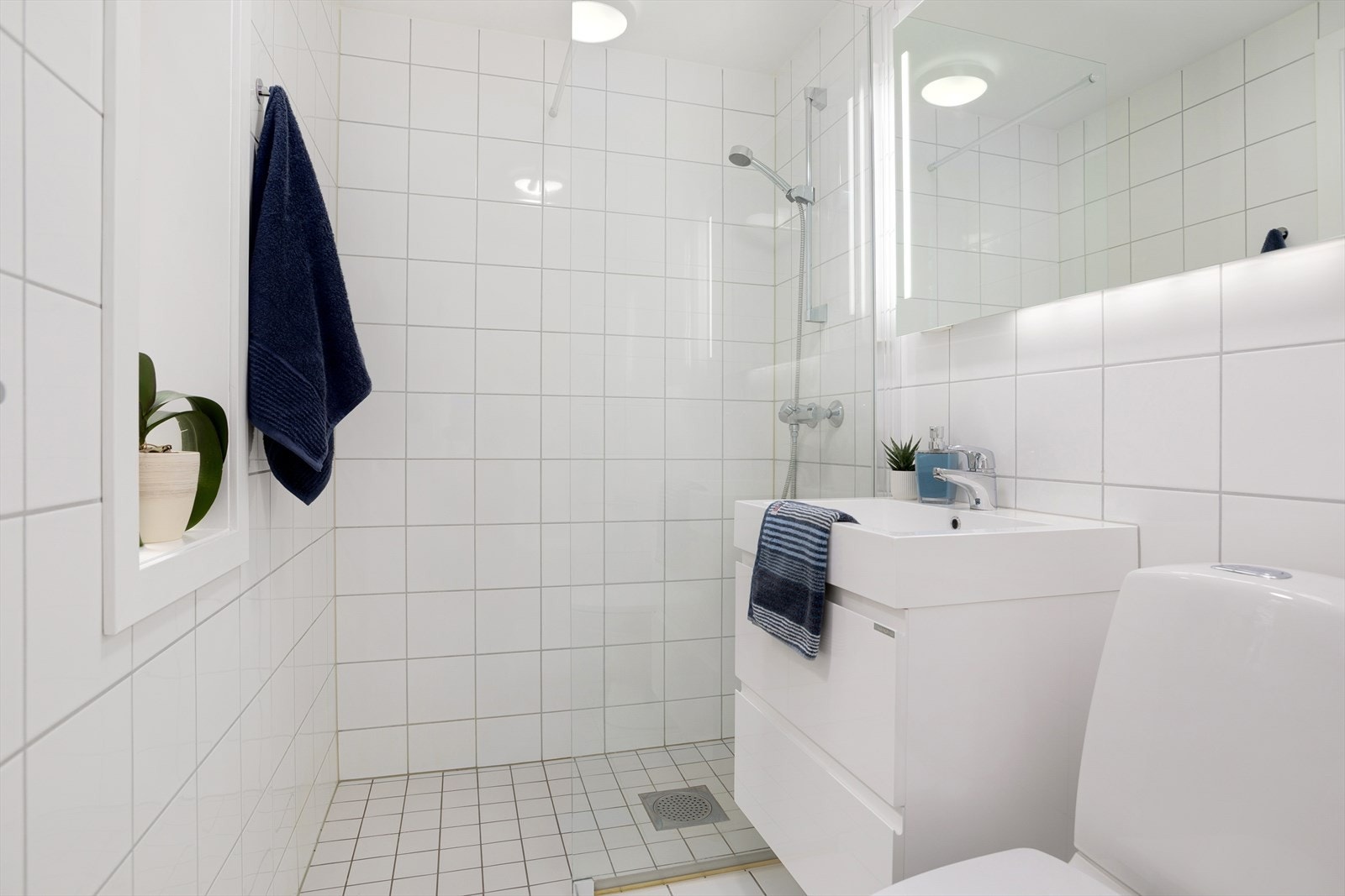 Delikat bad med dusjhjørne, speil, servant med skuffer og wc i tilknytning til hovedsoverommet. Galleribilde