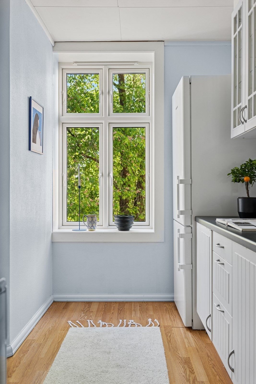 Kjøkkenet ligger i et separat rom, som skaper et ekstra oppholdsrom i boligen. Her er det godt med skap- og benkeplass med innredning på to sider av rommet. Galleribilde