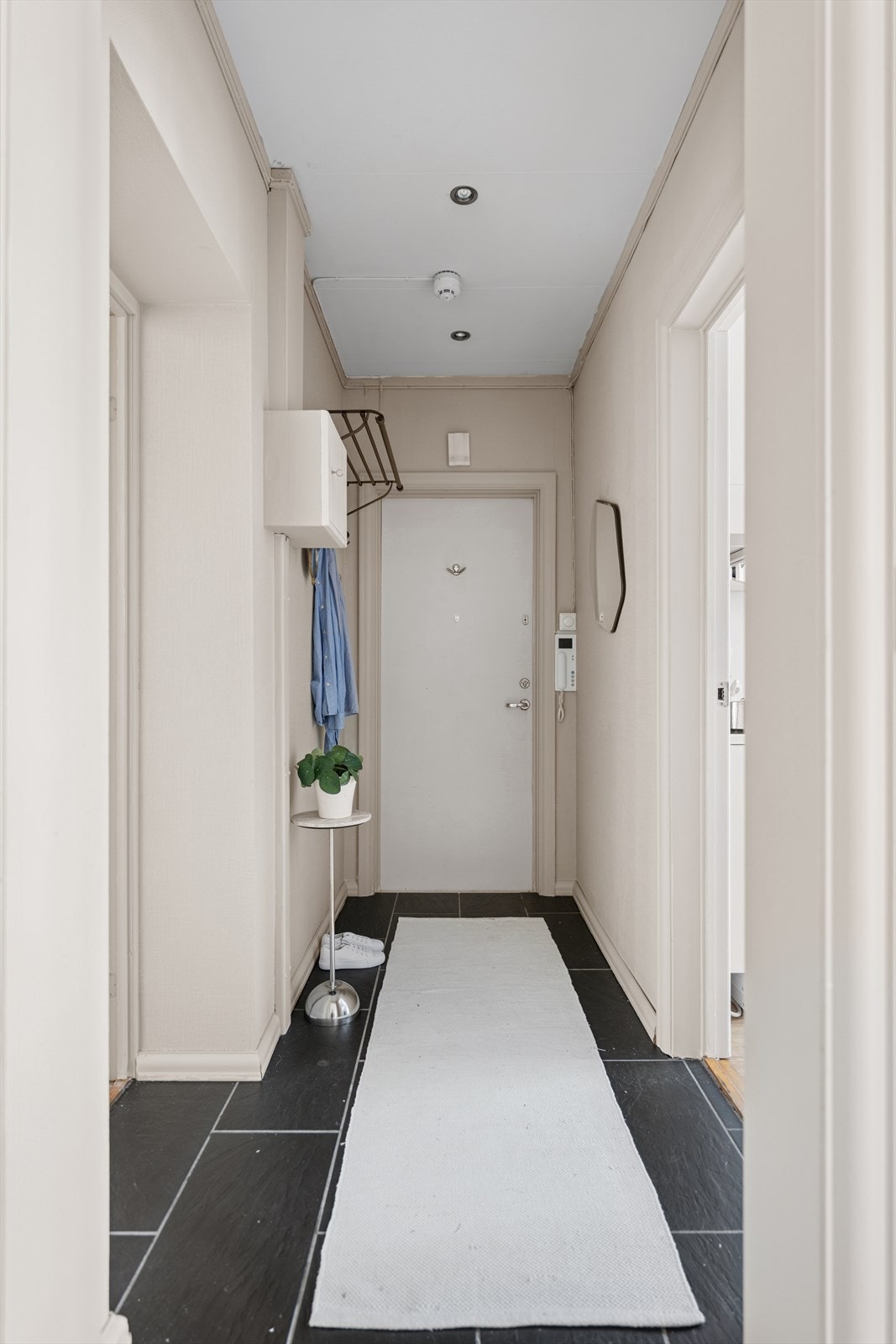 Lys og innbydende entré med flislagt gulv, lysmalte overflater og downlights i himlingen. Galleribilde