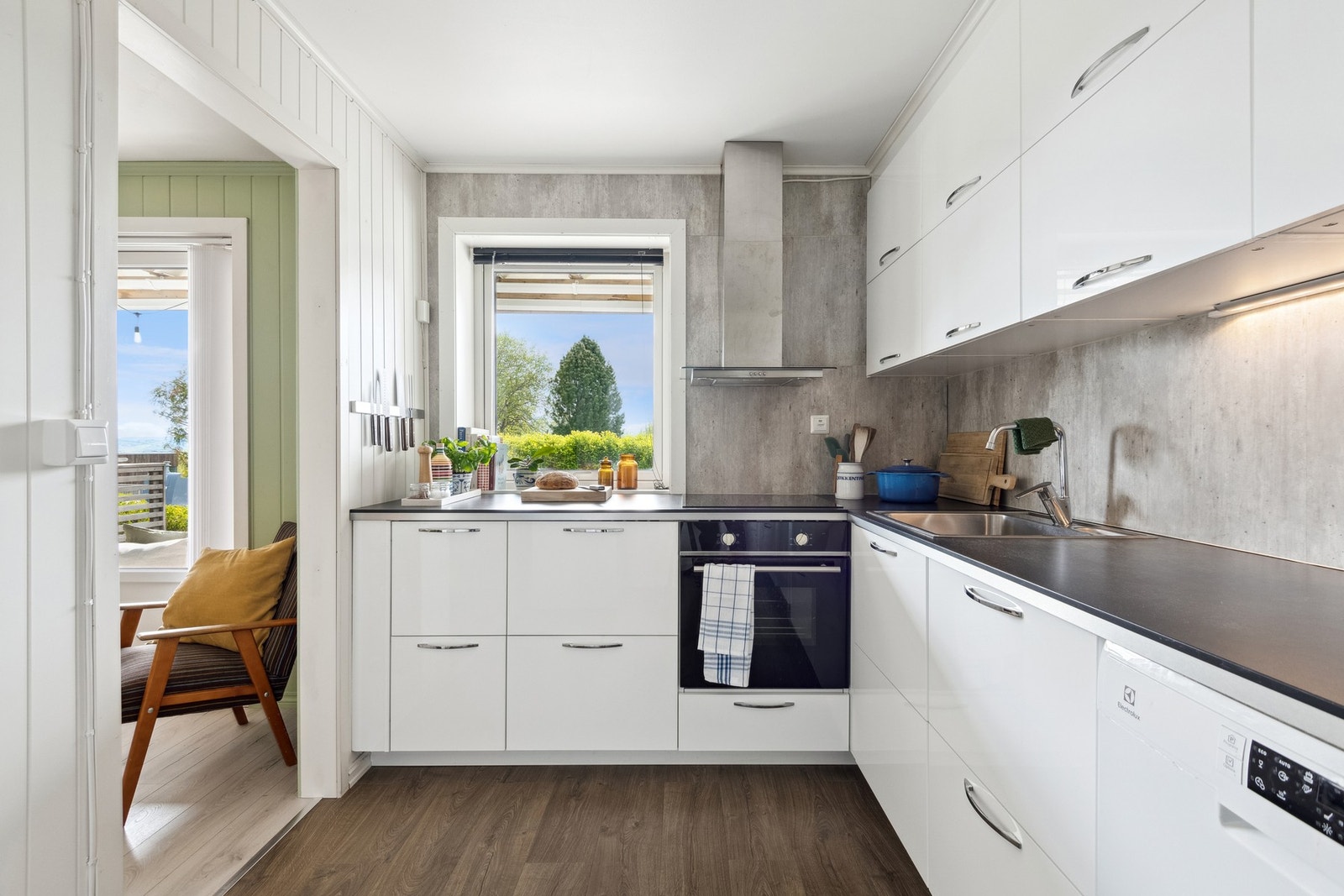 Lyst og moderne kjøkken med avsatt plass til vaskemaskin. Galleribilde