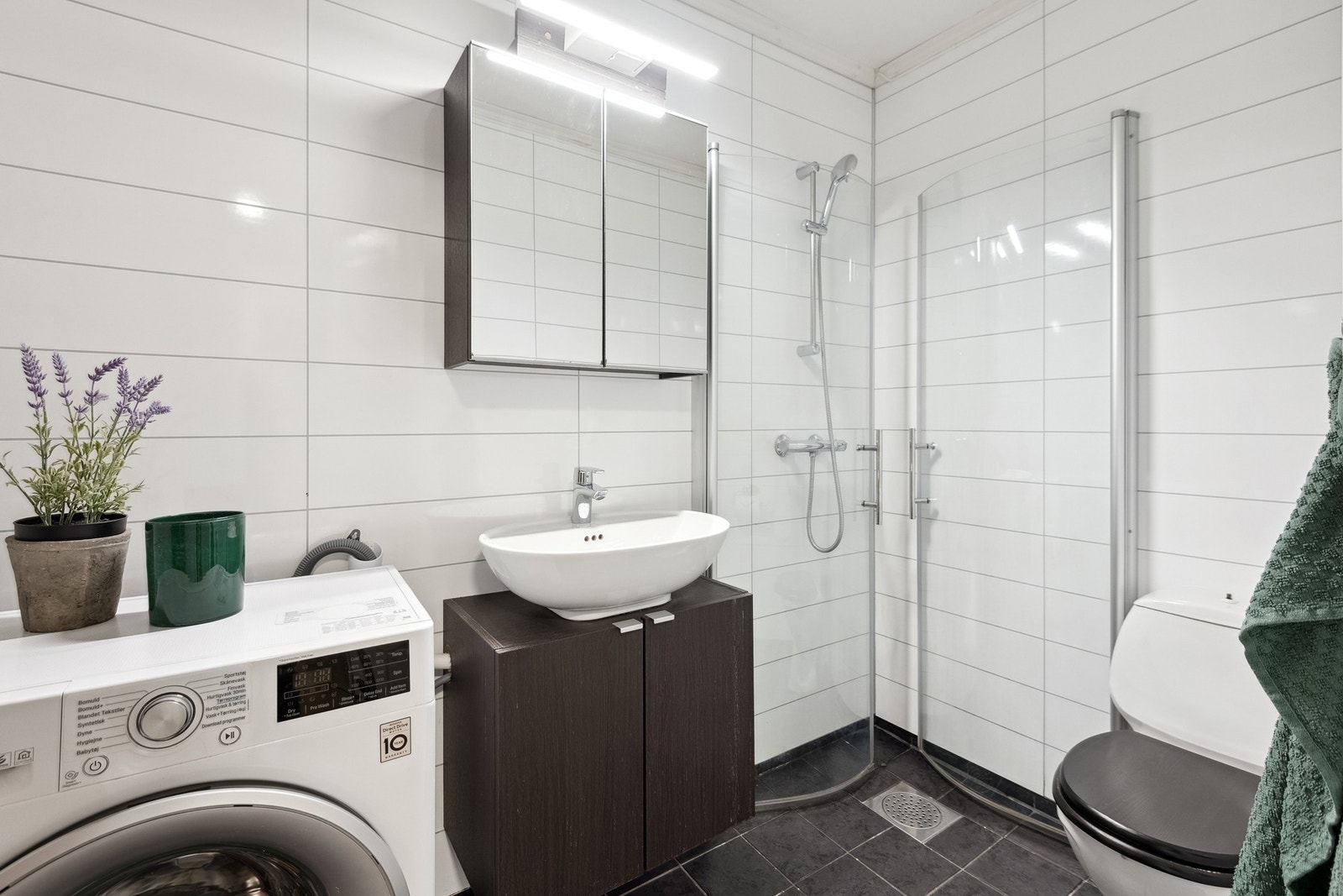 Badet har opplegg for vaskemaskin, varmekabler på gulv og dusjhjørne. Galleribilde