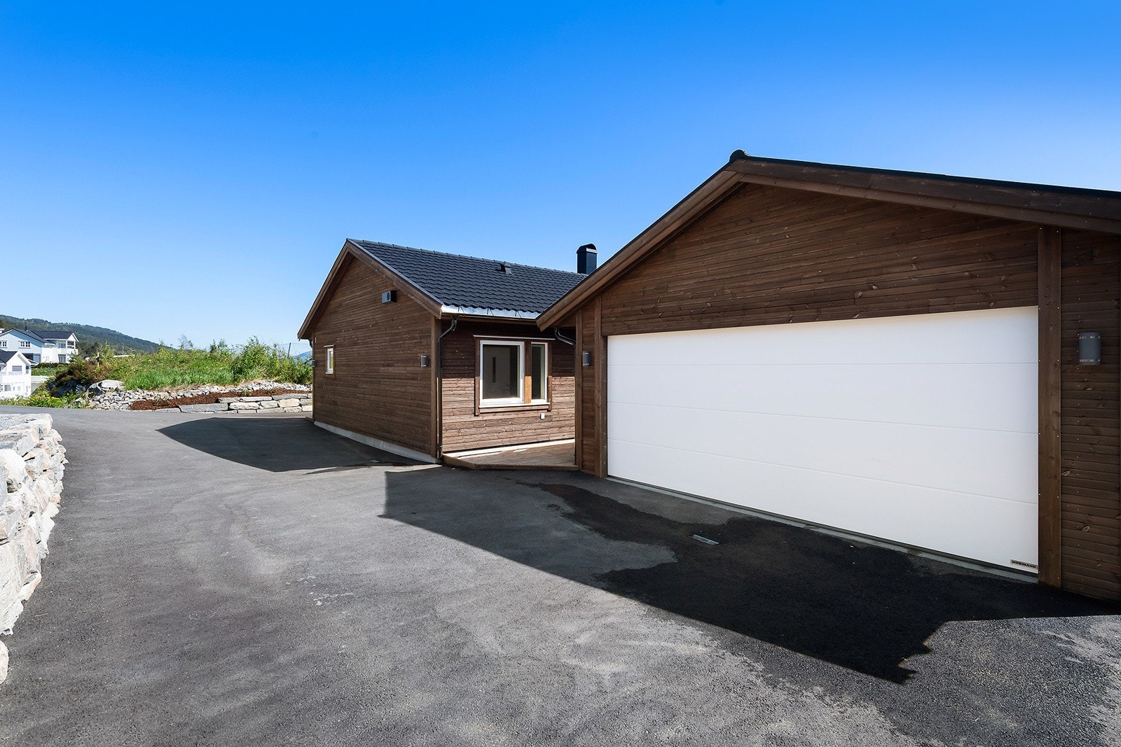 Asfaltert innkjørsel med garasje og parkeringsplass Galleribilde