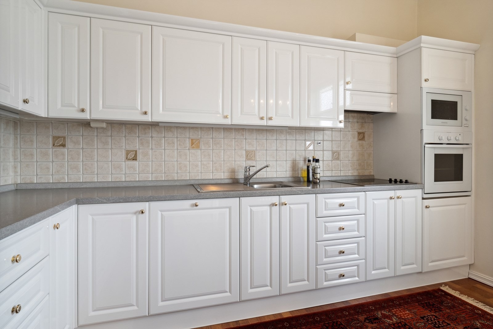 Kjøkkenet har en hvit profilert innredning på skap- og skuffer, og godt med skap- og benkeplass. Galleribilde