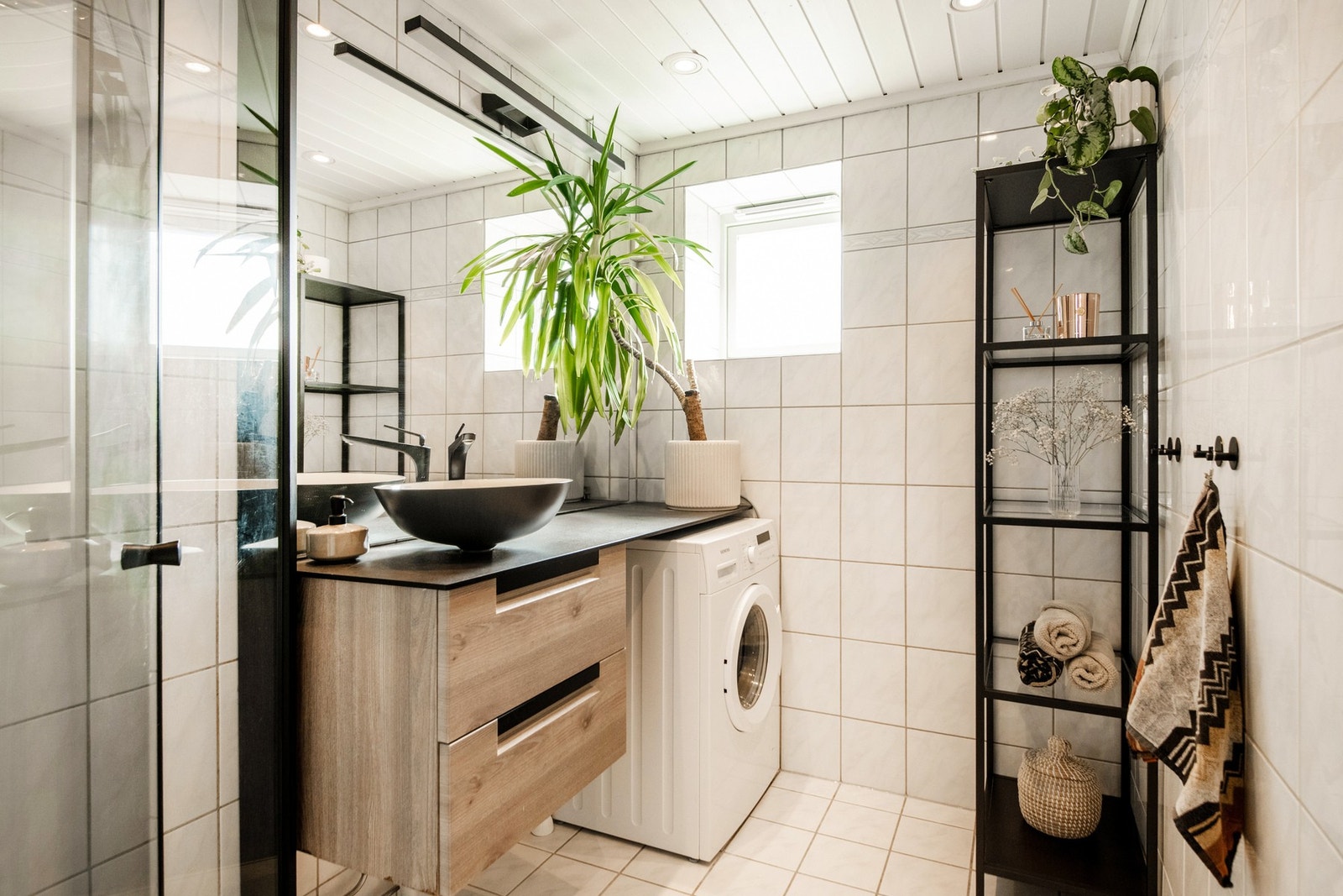 Flislagt baderom med et vindu som gir naturlig dagslys og mulighet for effektiv lufting. Galleribilde