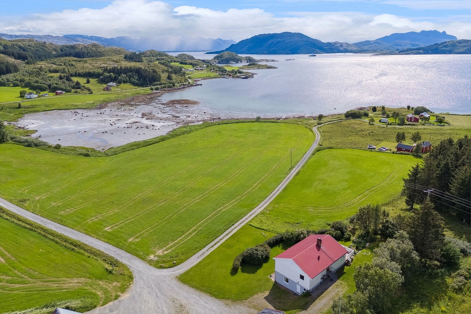 Løkta er en frodig øy, og området rundt boligen er intet unntak. Her ser man sjøen, de grønne markene, naboer, fjellene Dønnamannen på Dønna og De syv søstre i Sandnessjøen. Galleribilde