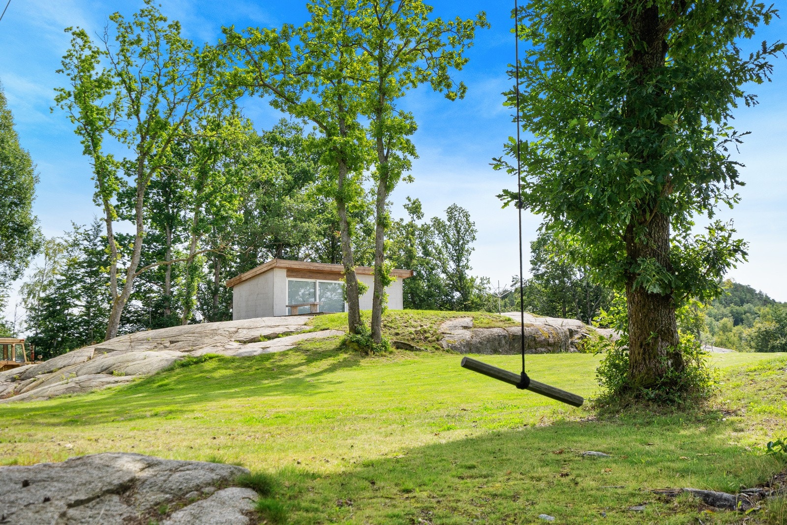 Eiendommen er flott opparbeidet med store gresslagte områder øverst på kollen, med et anneks plassert på toppen. Galleribilde