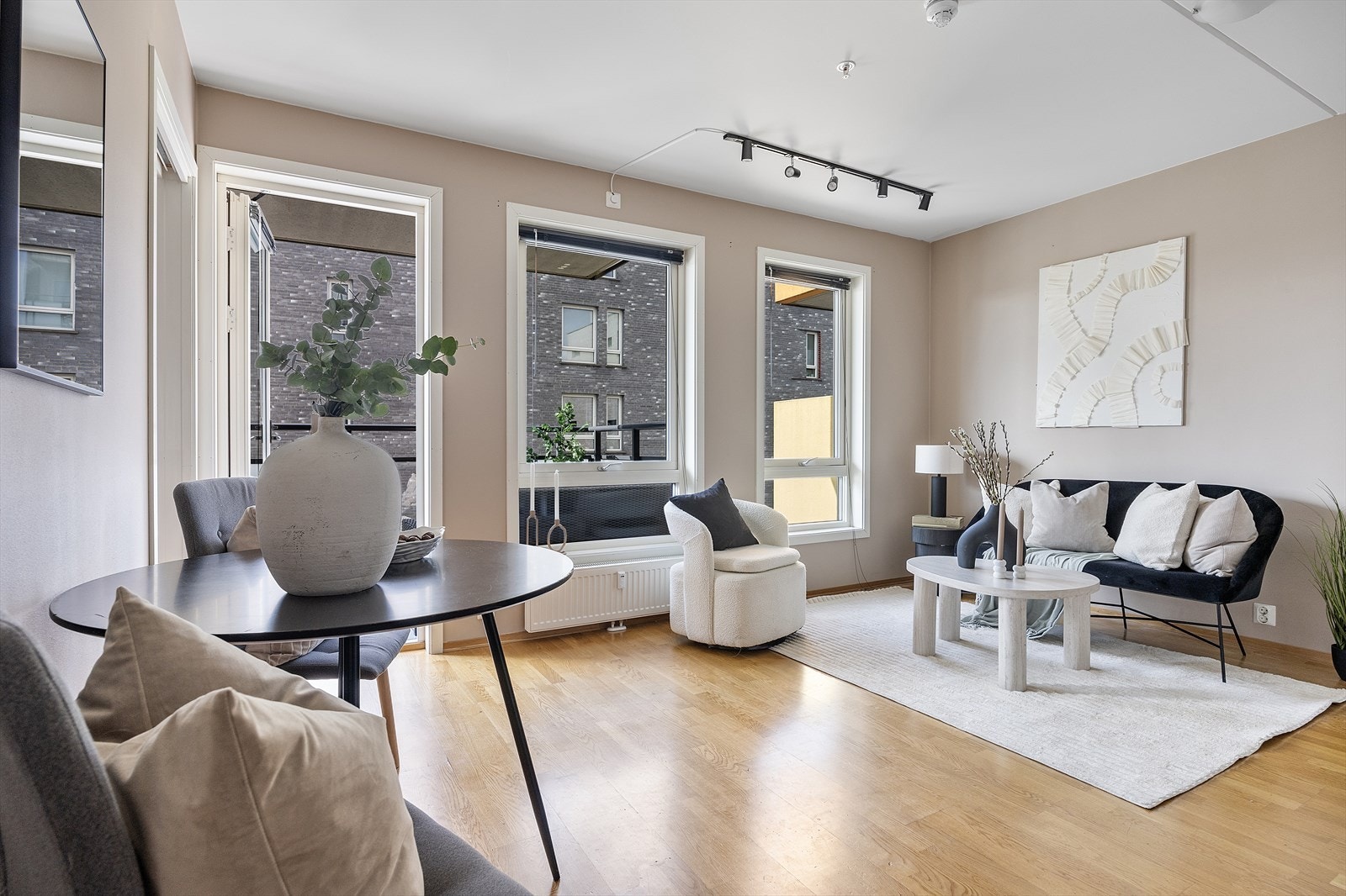 Stuen i leiligheten er romslig og flott opplyst med store vindusflater som gir rikelig med naturlig lys, og skaper en god atmosfære. Galleribilde