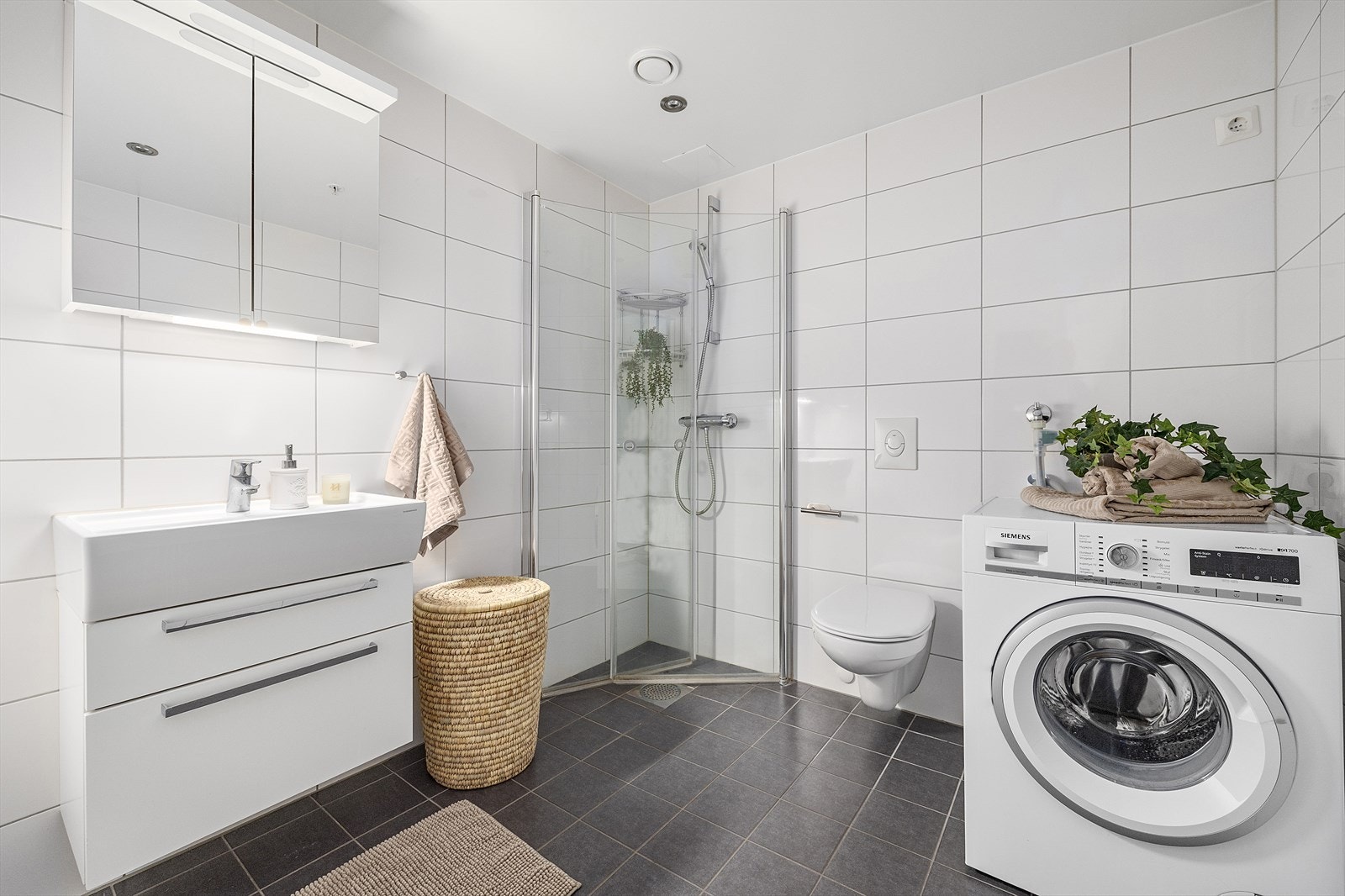 Pent, flislagt bad med god standard. Badet er utstyrt med varmekabler igulvet, en praktisk dusjnisje med innfellbare glassdører. Galleribilde