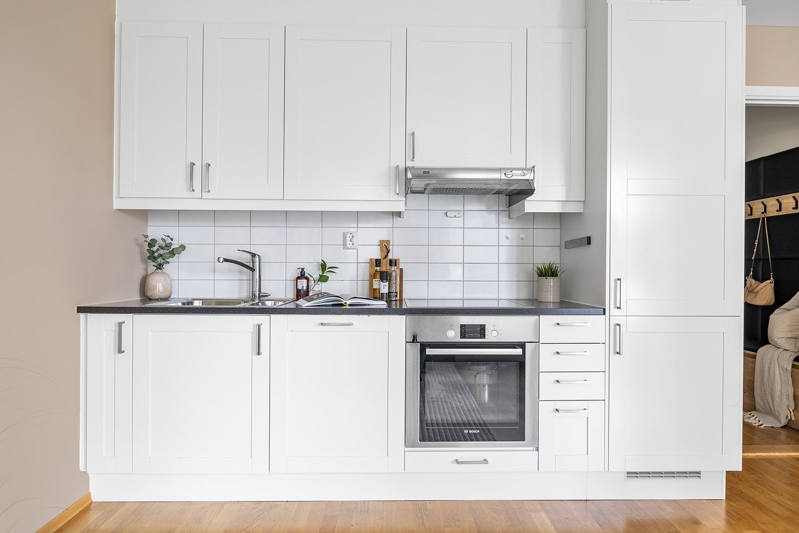 Ventilator med mekanisk avtrekk over koketopp. Kjøkkenet er også utstyrt med komfyr, oppvaskmaskin og kjøl/frys. Galleribilde