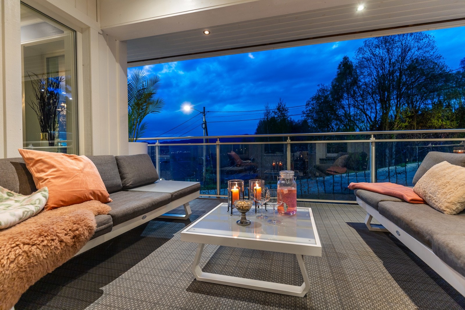 Overbygd balkong med sittegruppe og utsikt mot kveldshimmel. Galleribilde