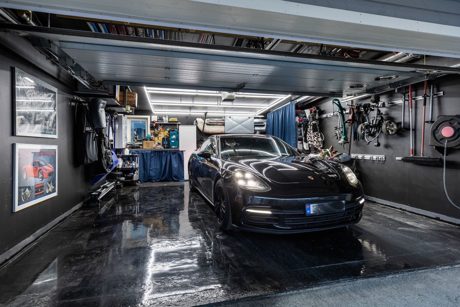 Dobbelgarasje med god plass til bil, oppbevaring og verksted. Vegghengt utstyr og belysning gir et organisert og funksjonelt rom. Galleribilde