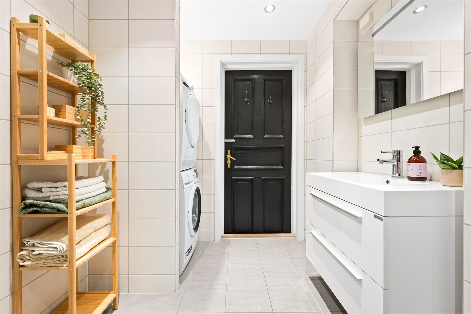 Badet er innredet med vegghengt toalett, dusjhjørne med svingbare glassdører og baderomsinnredning med skuffer, servant nedfelt i innredning og speil med belysning. Galleribilde