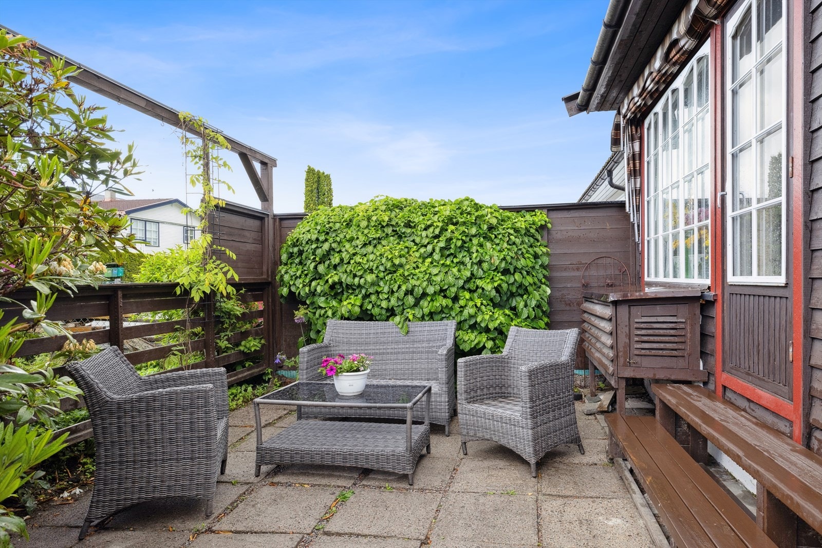 Utenfor døren er det tilgang til en skjermet og hyggelig uteplass, omkranset av frodige vekster. Galleribilde