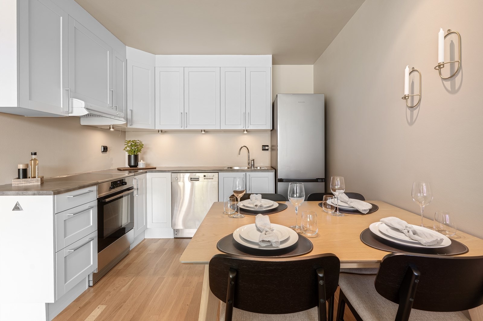 Kjøkkenet har hvite, profilerte fronter og lys benkeplate. Galleribilde