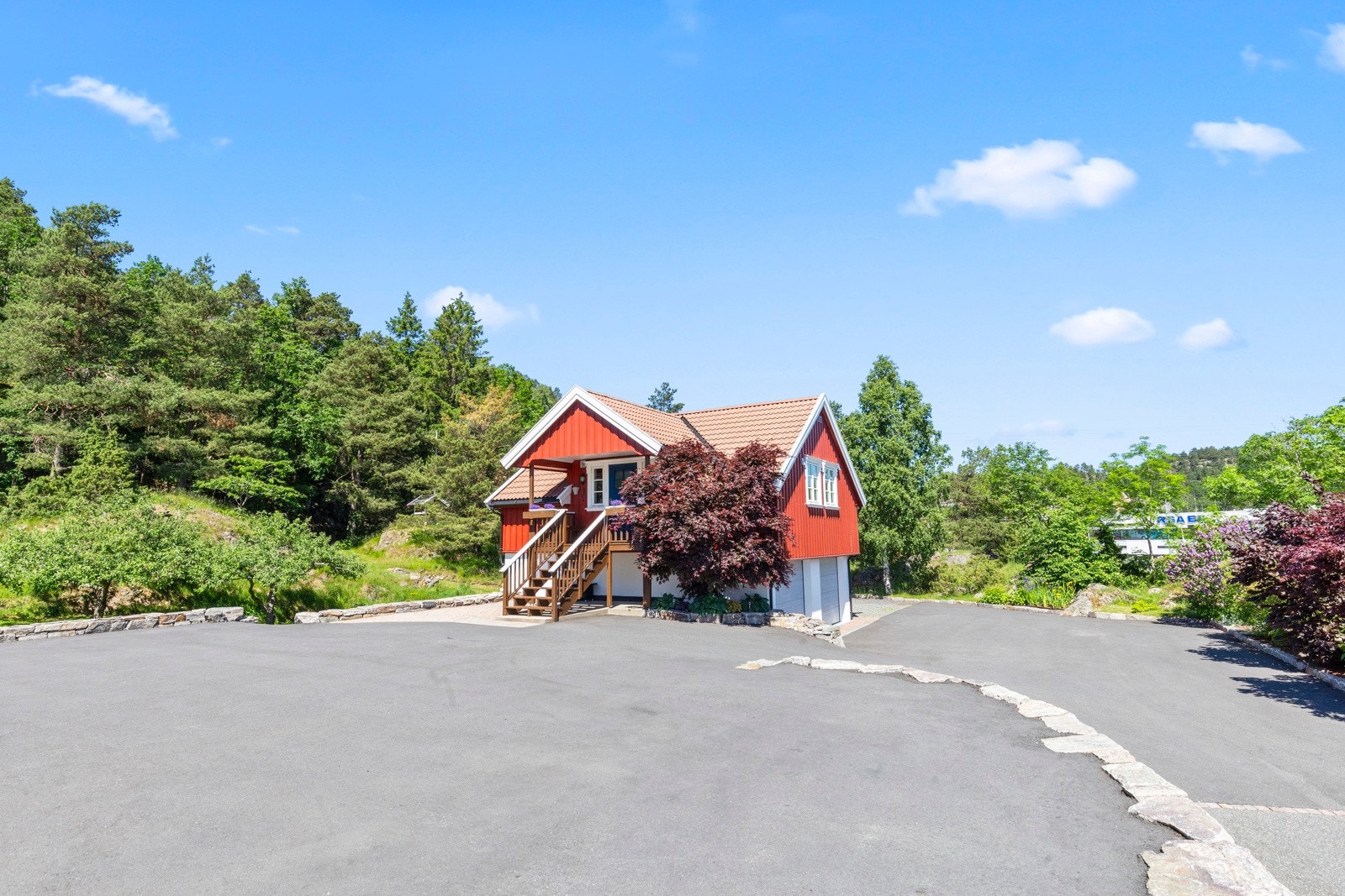 Gårdplassen og adkomstveien er asfaltert og det er god plass til mange biler på tomten. Galleribilde