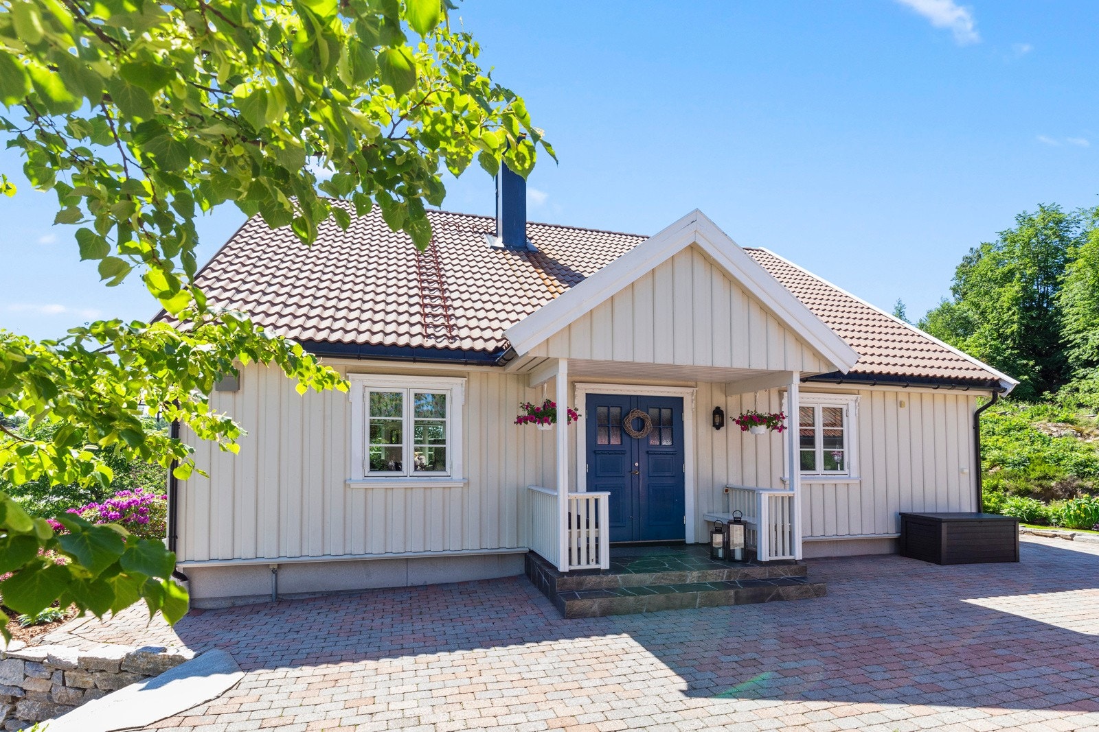 Huset er omringet av vakre bedd, trær og variert beplantning som gir et frodig og innbydende preg. Galleribilde