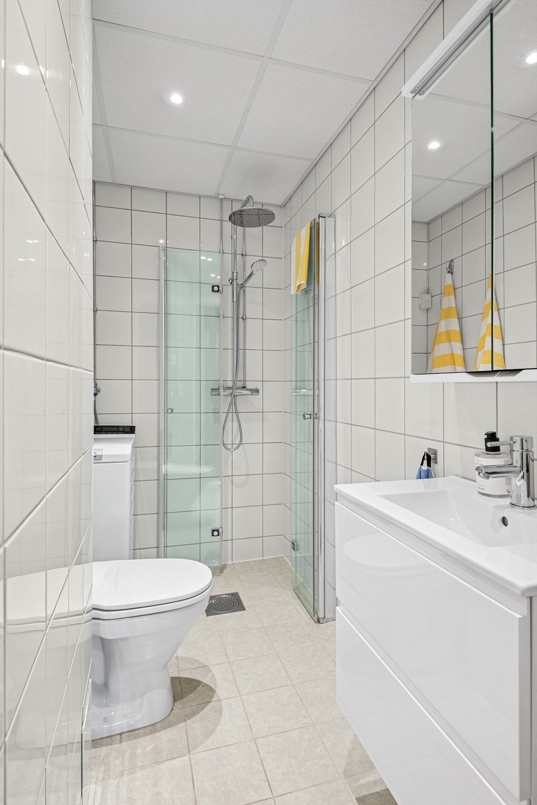 Flislagt baderom med gulvvarme og vaskemaskin. Galleribilde