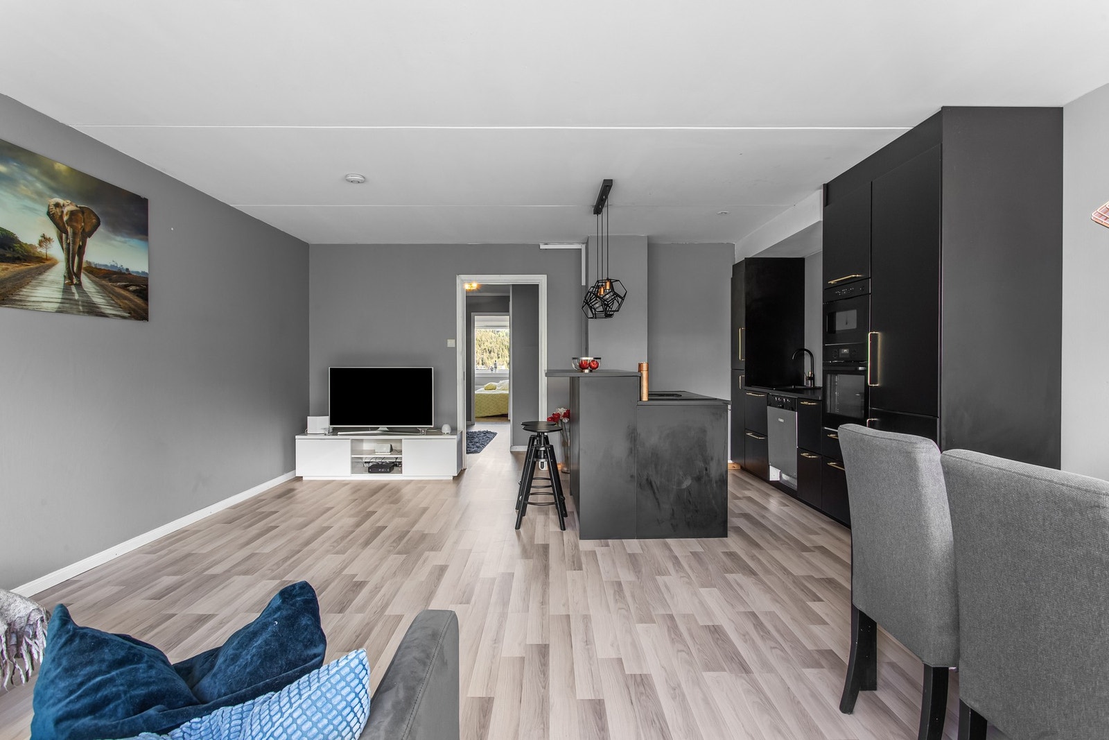 Moderne kjøkken i svart med glatte fronter og åpen løsning mot stuen. Galleribilde