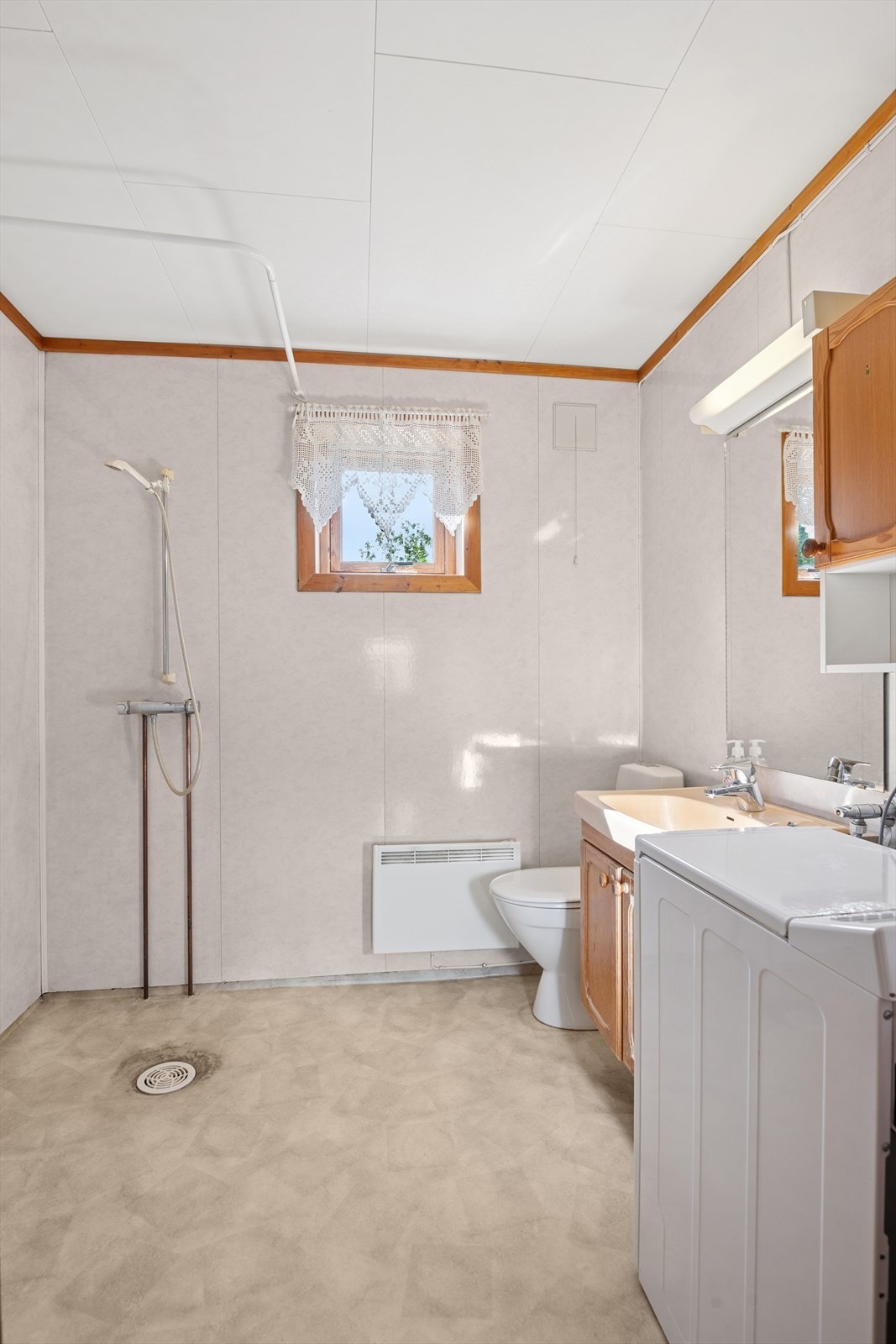 Badet har opplegg for vaskemaskin og god lagringsplass. Galleribilde